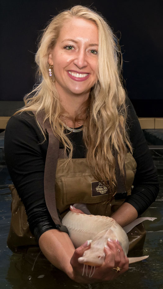 Founder Kristen McGee with sturgeon at the hatchery